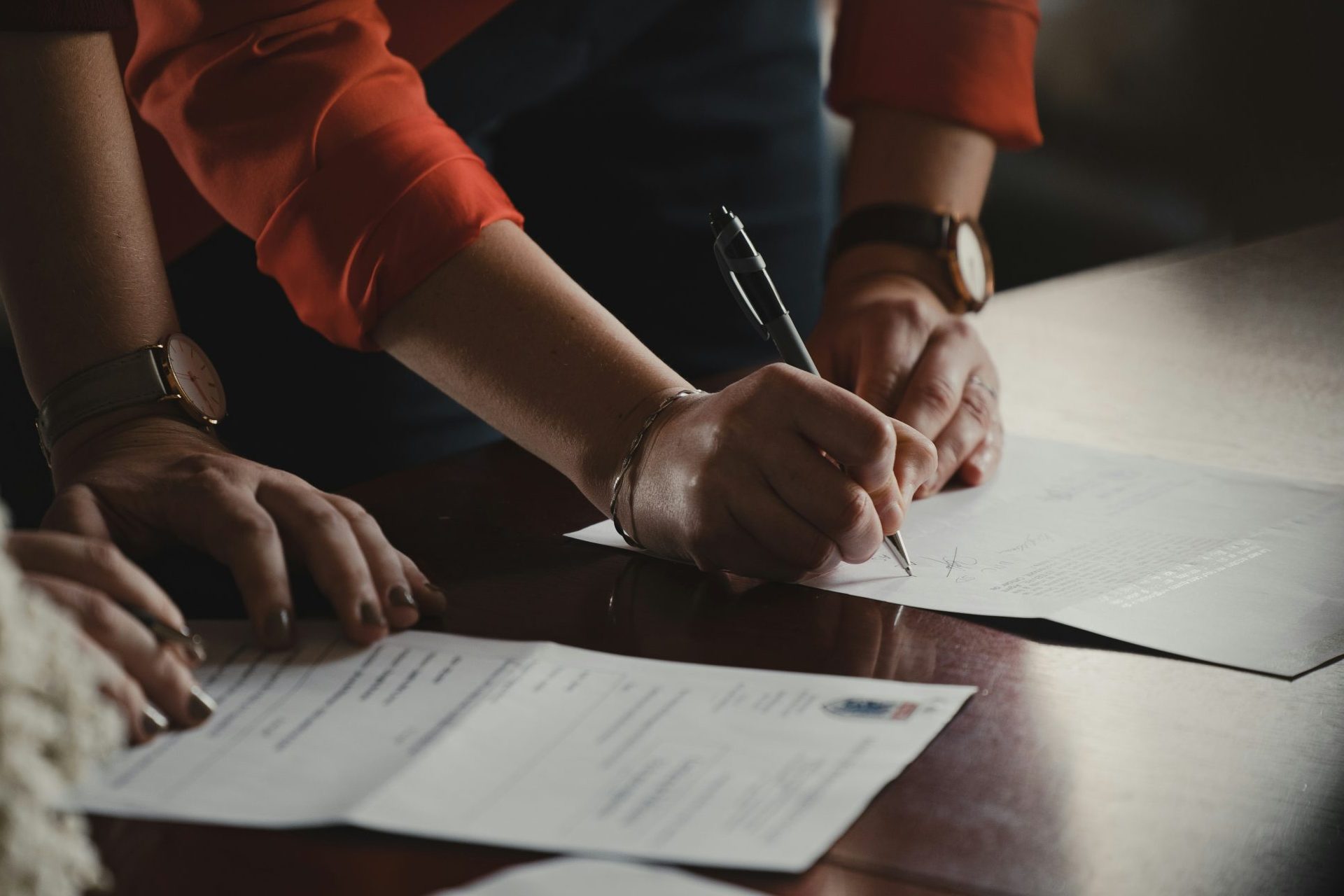 Women signing or filling out documents.