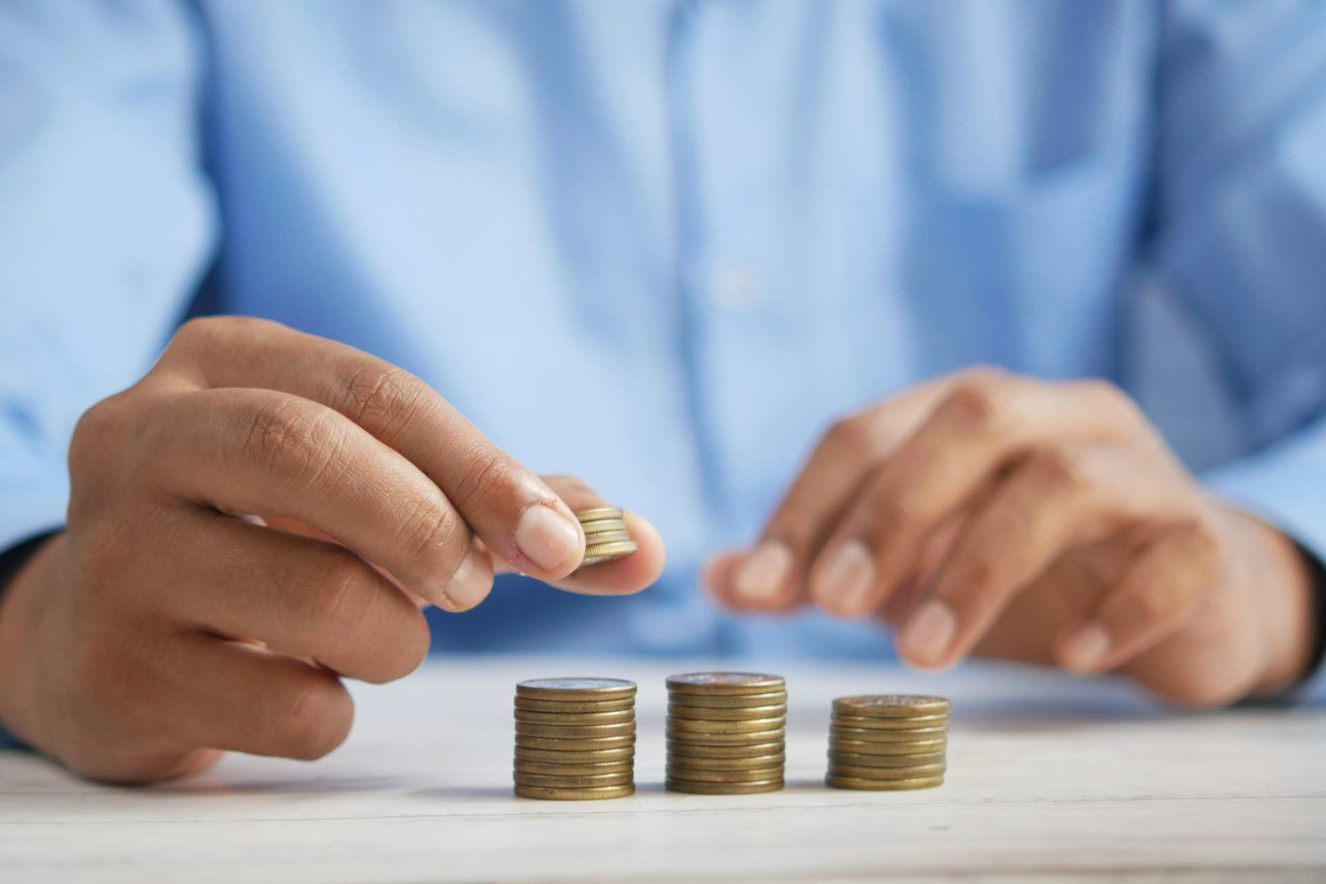 Man organizing coins or money into piles illustrating growth.